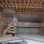 Contractor spraying closed-cell spray foam insulation inside a 16,000 square foot warehouse in Kalispell Montana.